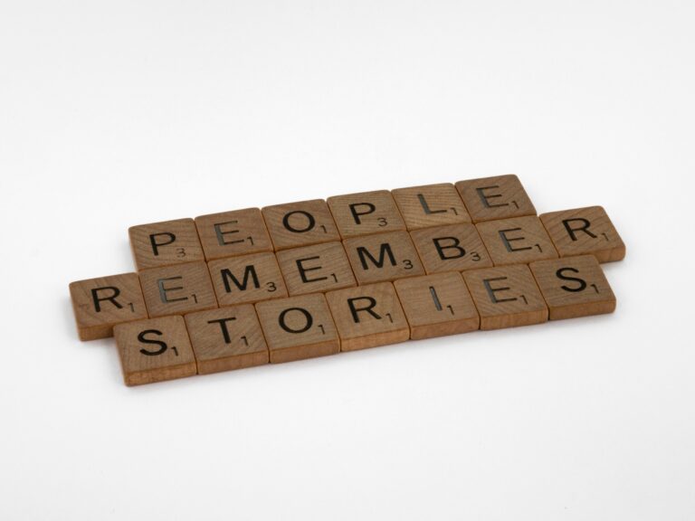 Scrabble letter tiles spell out three words: People Remember Stories"